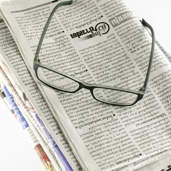 Zeitungsstapel mit Brille — Stockfoto