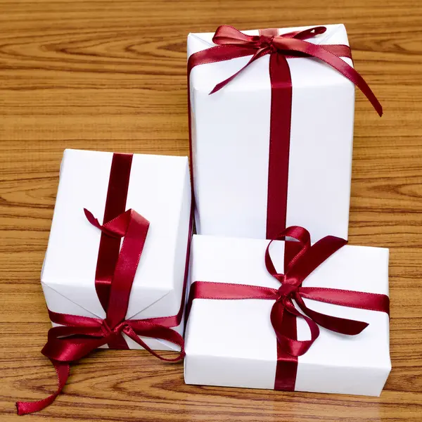 Caja de regalo blanca con cintas rojas — Foto de Stock