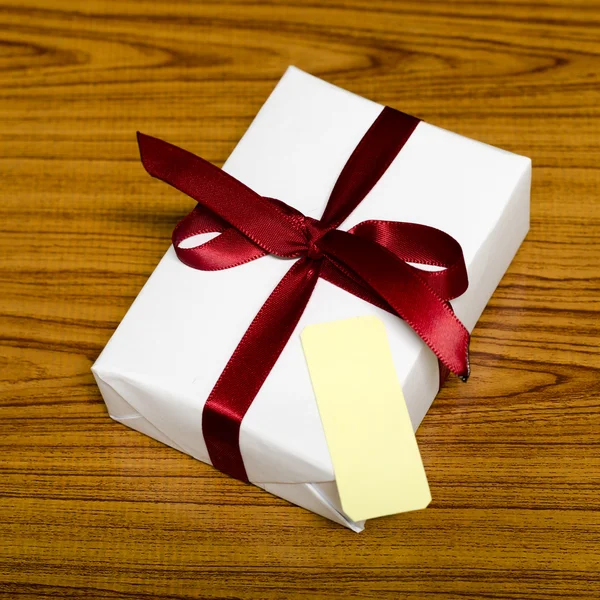 Белый ящик подарка и красная лента с биркой — стоковое фото