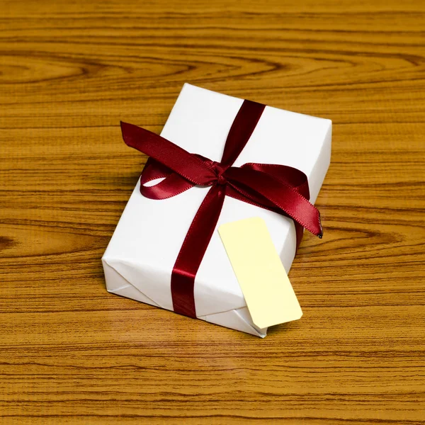 Caja de regalo blanca y cinta roja con etiqueta — Foto de Stock