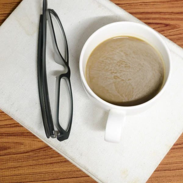 Tazza di caffè e taccuino con bicchieri — Foto Stock