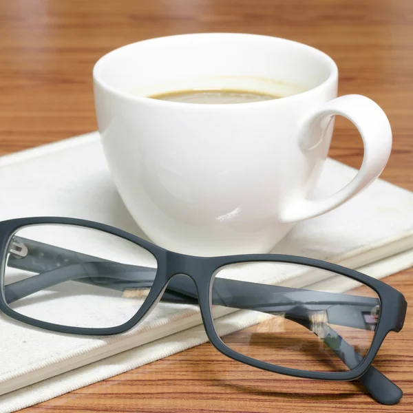 Xícara de café e caderno com óculos — Fotografia de Stock