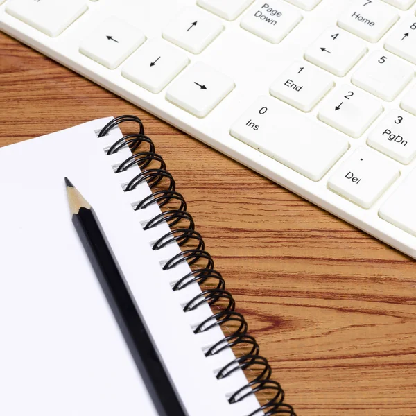 Tangentbordet datorn med notenook och penna — Stockfoto