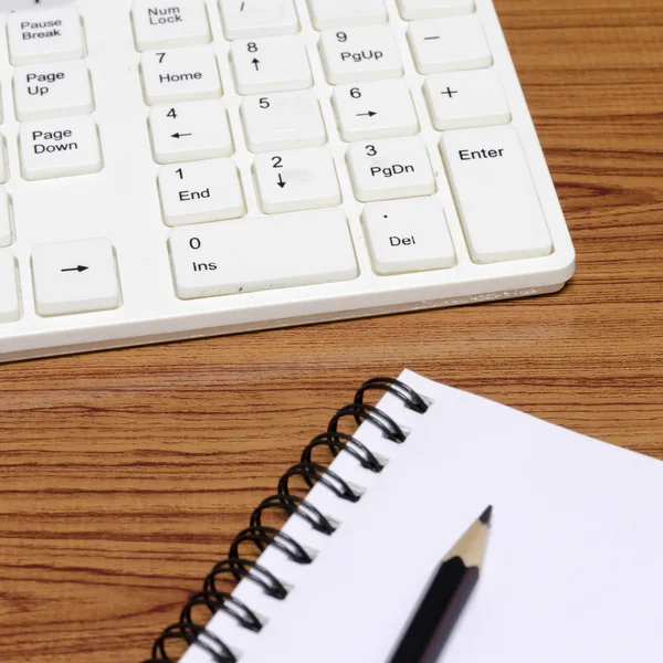 Tangentbordet datorn med notenook och penna — Stockfoto
