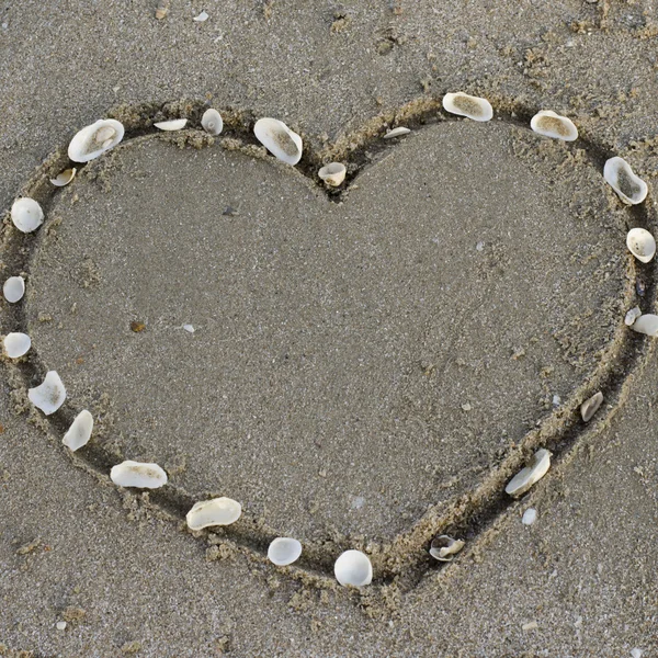 Sydän hiekalla rannalla — kuvapankkivalokuva