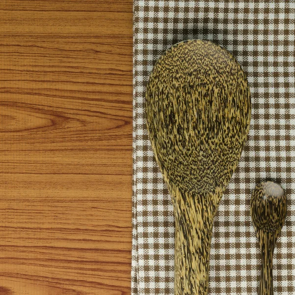Toalha de cozinha com colher no fundo de madeira — Fotografia de Stock