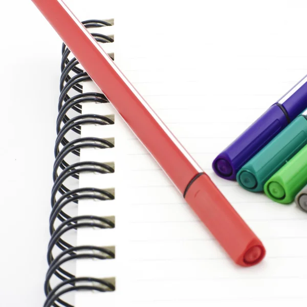 Kleurrijke pen met laptop geïsoleerd op wit — Stockfoto