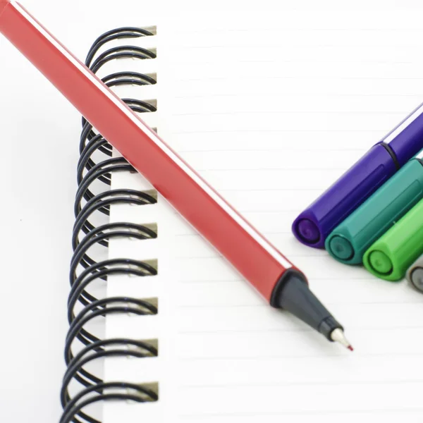 Kleurrijke pen met laptop geïsoleerd op wit — Stockfoto