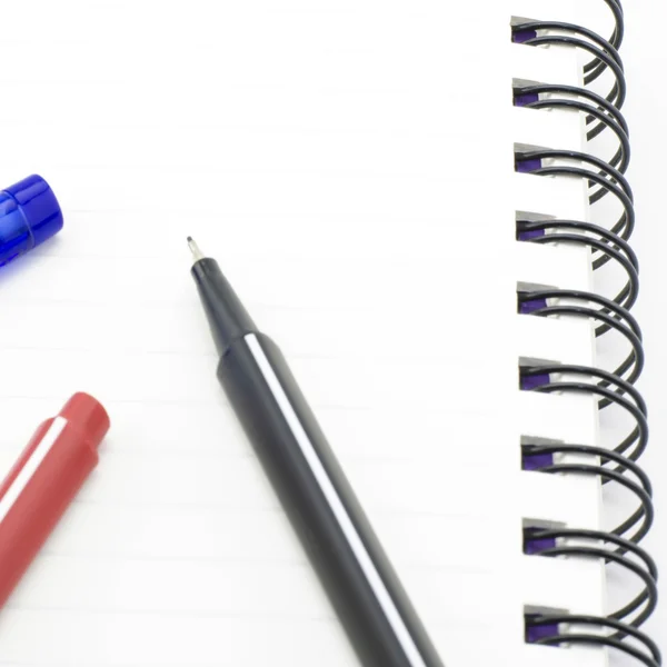 Negro pluma roja y azul con cuaderno aislado en blanco — Foto de Stock