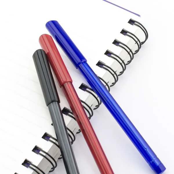 Black red and blue pen with notebook isolated on white — Stock Photo, Image