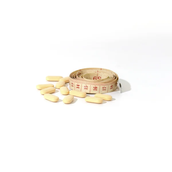 Pills and measuring tape — Stock Photo, Image