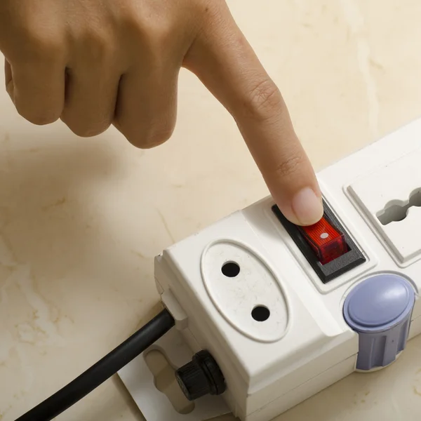 Hand turn on switch multiple  socket plug — Stock Photo, Image