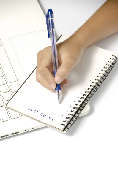 Frau schreibt mit Stift auf Notizbuch — Stockfoto