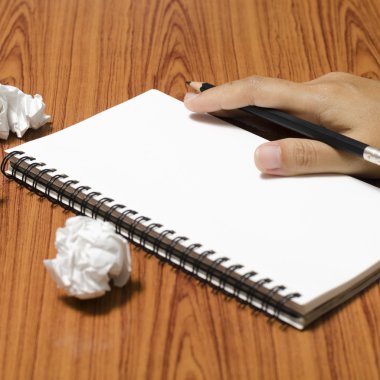 hand writing on notebook with crumpled paper