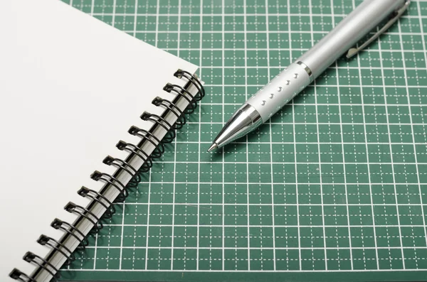 Caderno e caneta no tapete de corte — Fotografia de Stock