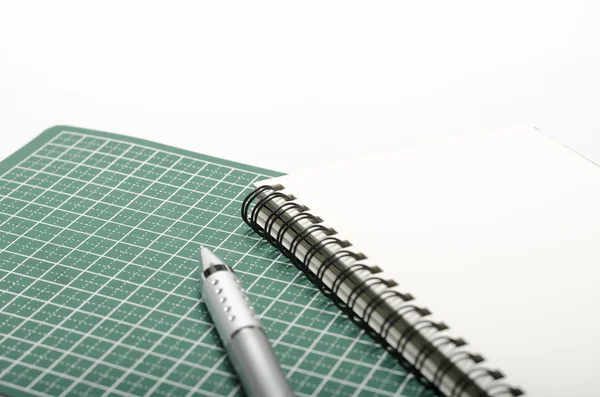 Notebook and pen on cutting mat — Stock Photo, Image