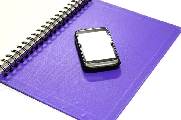 Используемый смартфон с серой записной книжкой — стоковое фото