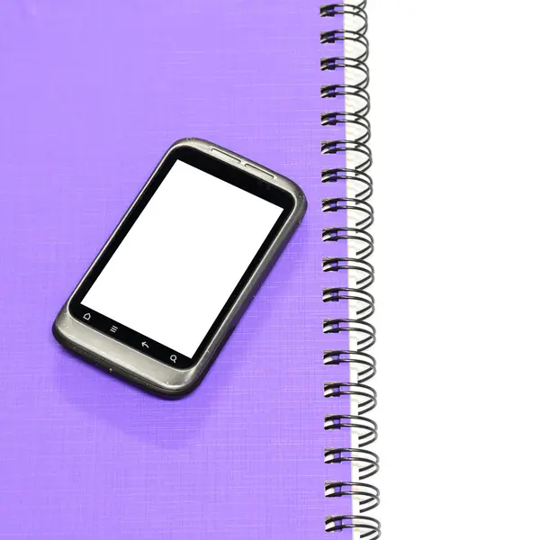 Smartphone på anteckningsbok — Stockfoto