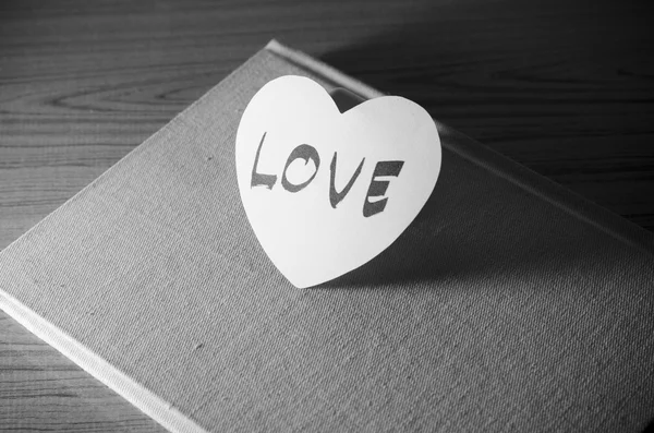 Corazón de papel blanco y negro con cuaderno — Foto de Stock