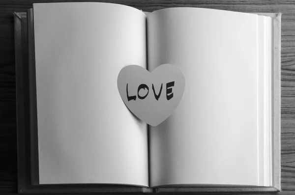 Corazón de papel blanco y negro con cuaderno — Foto de Stock