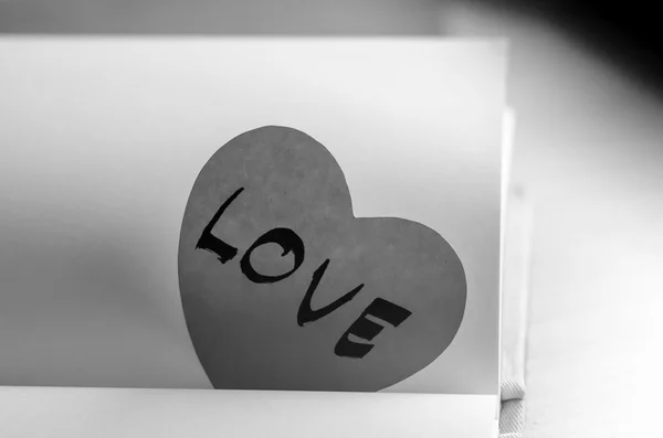 Corazón de papel blanco y negro con cuaderno — Foto de Stock