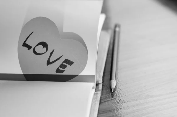 Corazón de papel blanco y negro con cuaderno — Foto de Stock