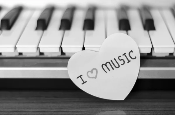 Papper hjärtat på piano keyboard svart och vitt — Stockfoto