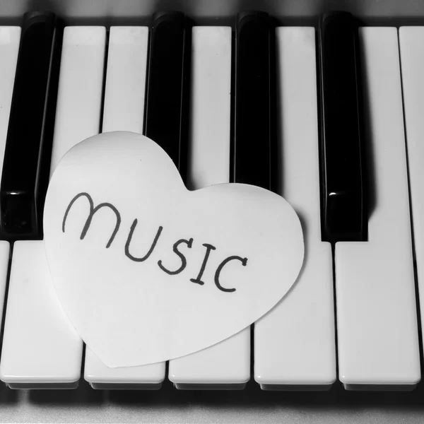 Corazón de papel en el teclado de piano blanco y negro — Foto de Stock