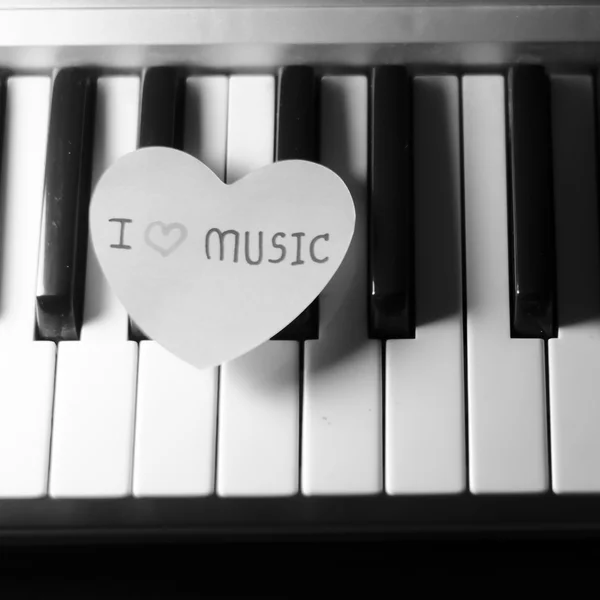 Paper heart on piano keyboard black and white — Stock Photo, Image