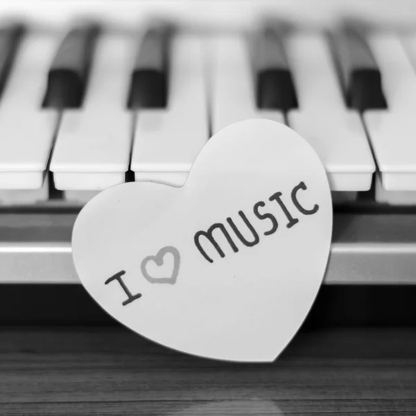 Paper heart on piano keyboard black and white — Stock Photo, Image