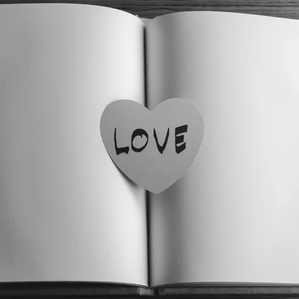 Corazón de papel blanco y negro con cuaderno — Foto de Stock