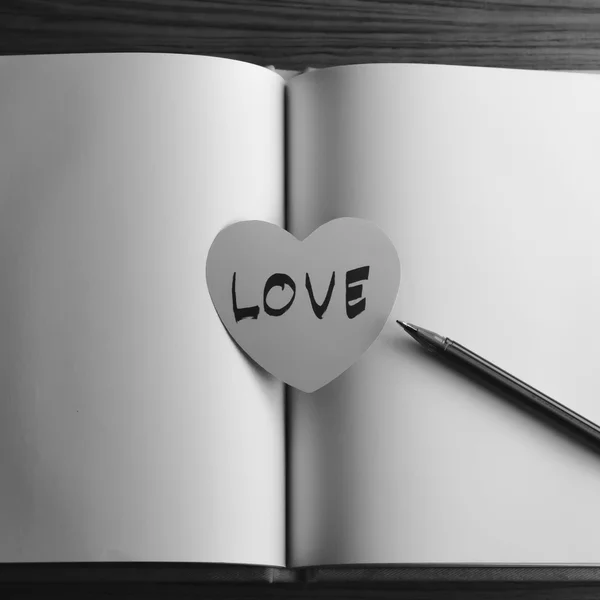 Corazón de papel blanco y negro con cuaderno — Foto de Stock