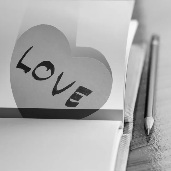 Corazón de papel blanco y negro con cuaderno — Foto de Stock