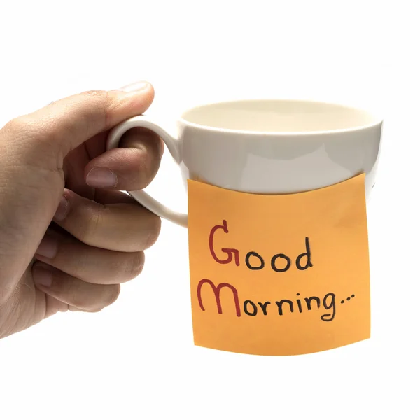 Ręka trzyma filiżanka kawy z notatka pisać dzień dobry — Zdjęcie stockowe