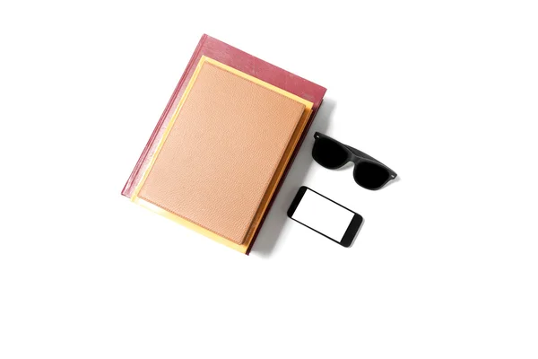 Okulary przeciwsłoneczne smartphone i stos książki — Zdjęcie stockowe