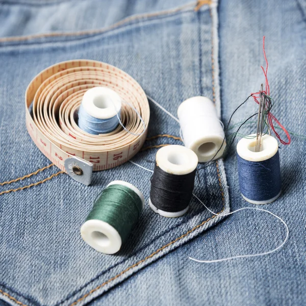 Джинсовые штаны и шитье — стоковое фото