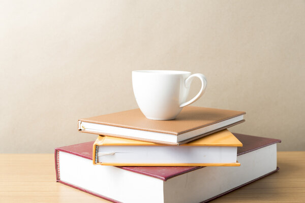 стопка книг с кофейной чашкой
