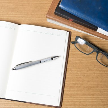 açık defter kitap yığını ile