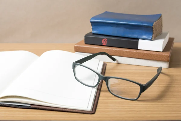 Cuaderno abierto con pila de libro — Foto de Stock