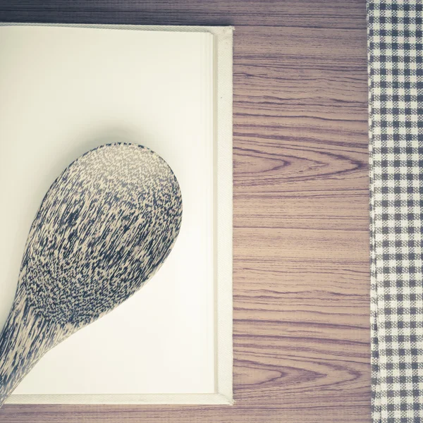 Kitchen towel with spoon on wood background — Stock Photo, Image