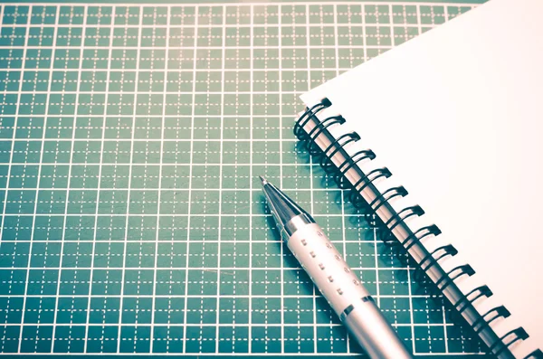 Caderno e caneta no tapete de corte — Fotografia de Stock