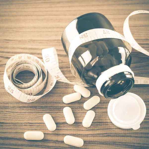 Pills and measuring tape — Stock Photo, Image