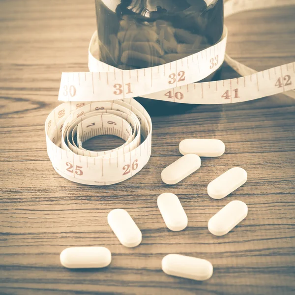 Pills and measuring tape — Stock Photo, Image