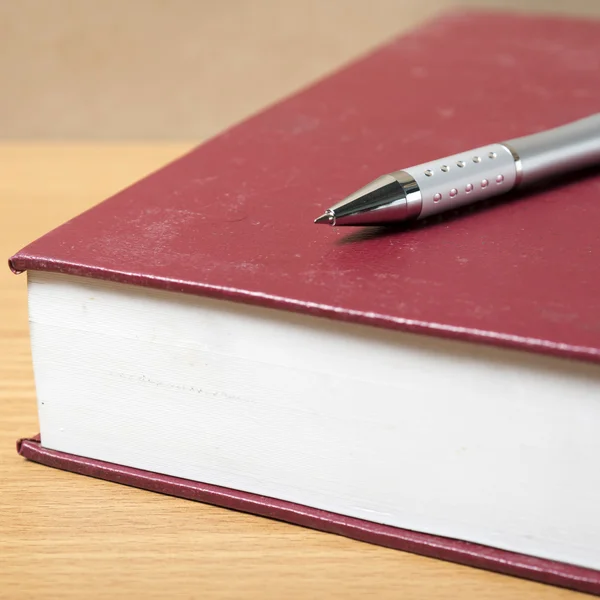 Bok och penna på bordet — Stockfoto