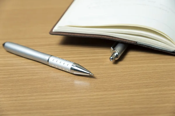 Book and pens on table — Stock Photo, Image