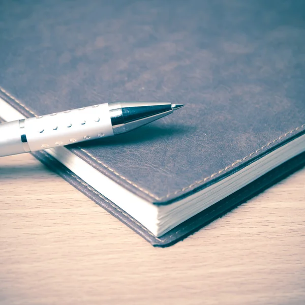 Книга и ручка на столе — стоковое фото