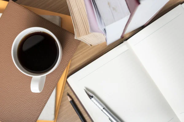 Carnet ouvert avec livre et tasse à café — Photo