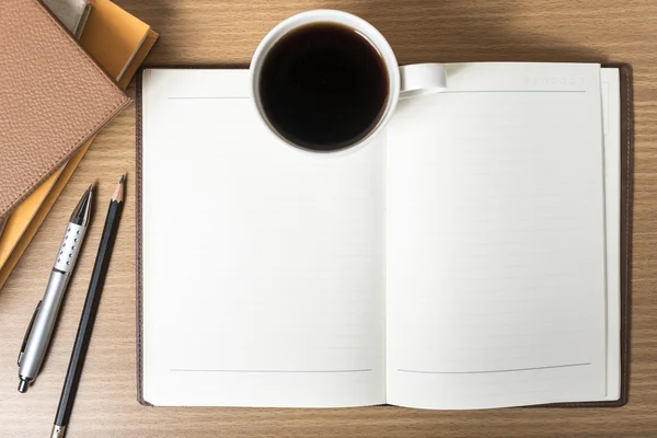 Notitieblok openen met boek en koffie beker — Stockfoto