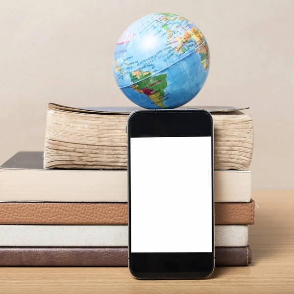 Buch und Erdball mit Smartphone — Stockfoto
