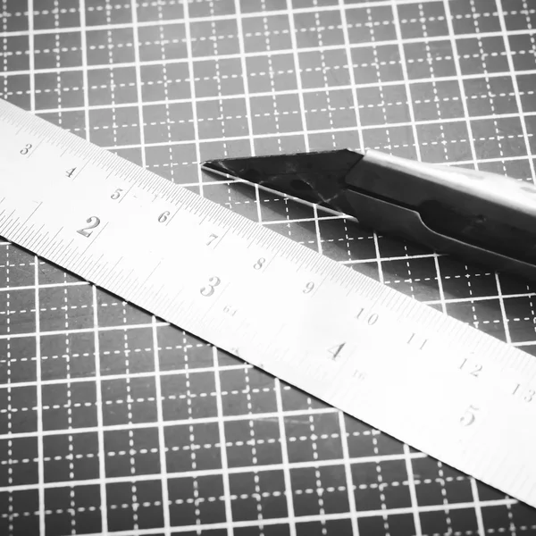 Ruler and cutter on cutting mat black and white color tone style — Stock Photo, Image